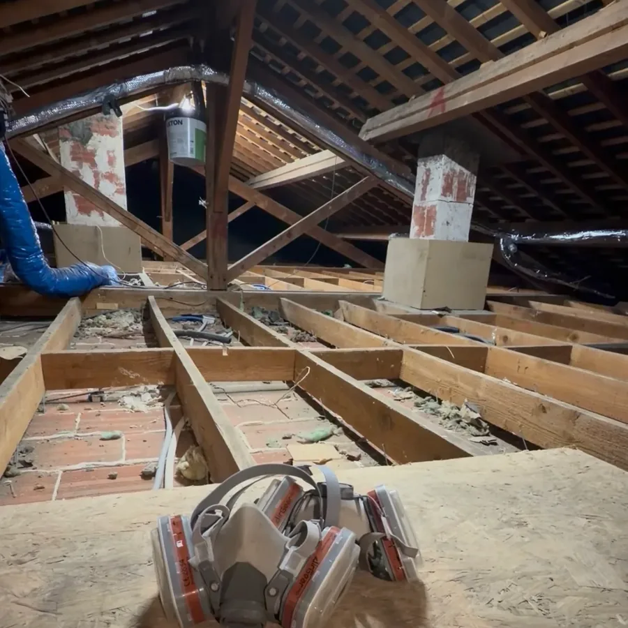 Combles perdus avant travaux : charpente apparente, solivage nu et gravats